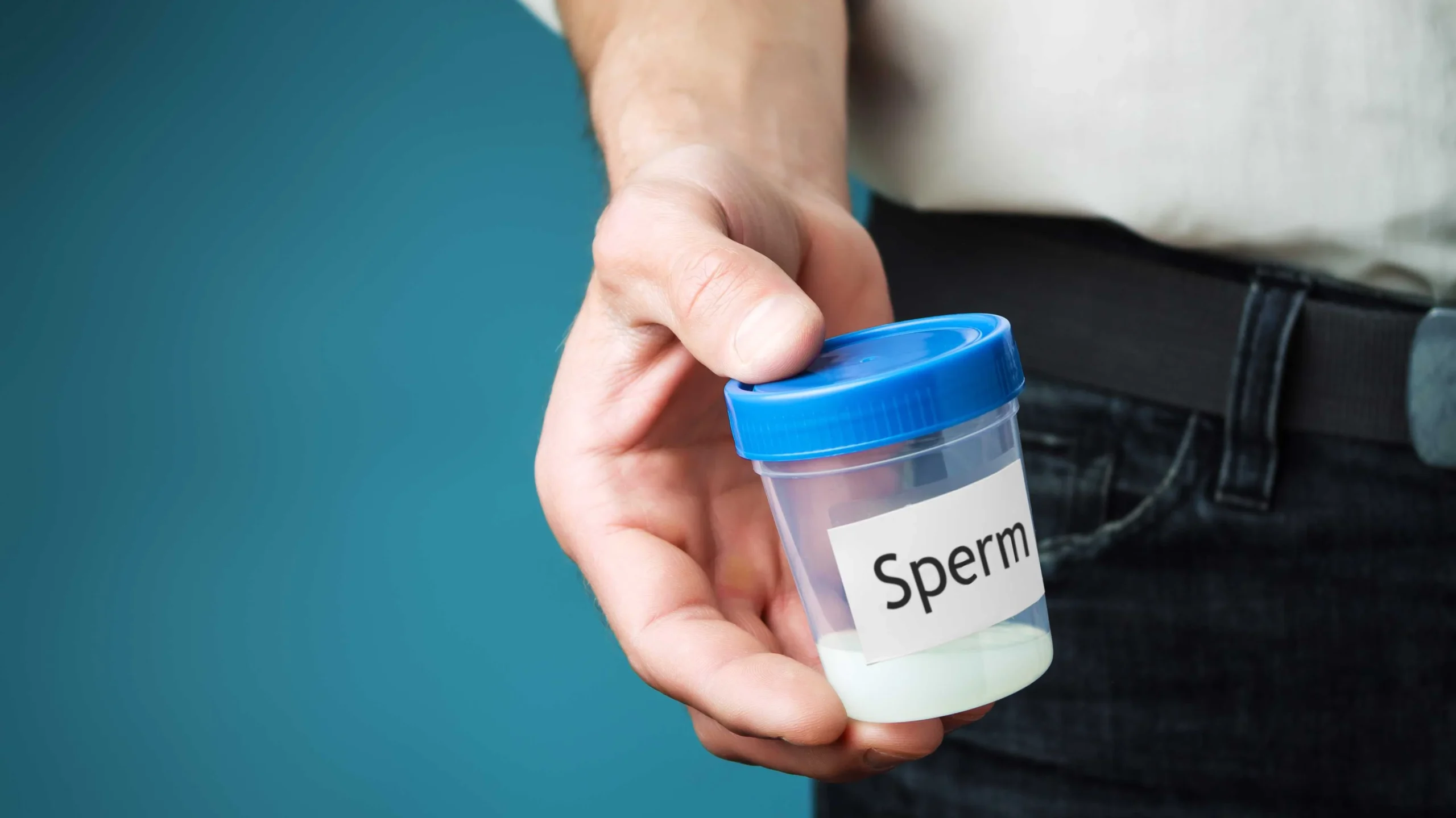 Container with sperm in a man's hand. Concept of donating sperm and testing fertility